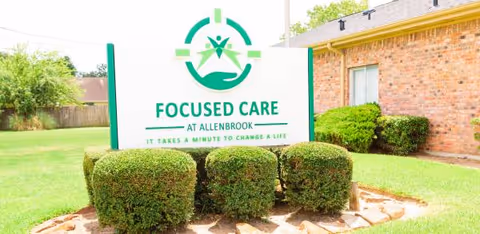 Front view of Focused Care at Allenbrook sign with trimmed hedges.