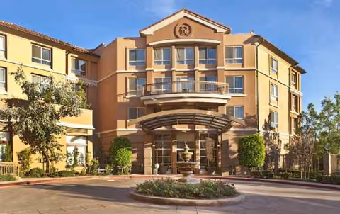 Front view of MorningStar of Pasadena senior living building with fountain and circular driveway.