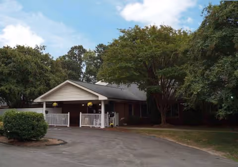 Wellington House front exterior with entrance porch and surrounding trees.