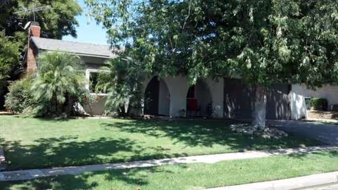 A single-story senior living facility with arches and a manicured front lawn.