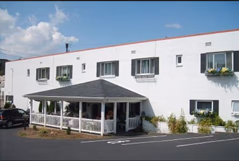 White two-story senior facility with a covered front porch and flower boxes.