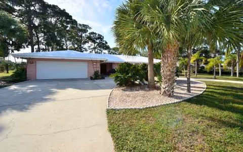 Front exterior of Sea View Inn at Forest Lakes with garage and palm trees