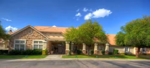 Front exterior of Brookdale East Arbor senior living facility with trees and parking.