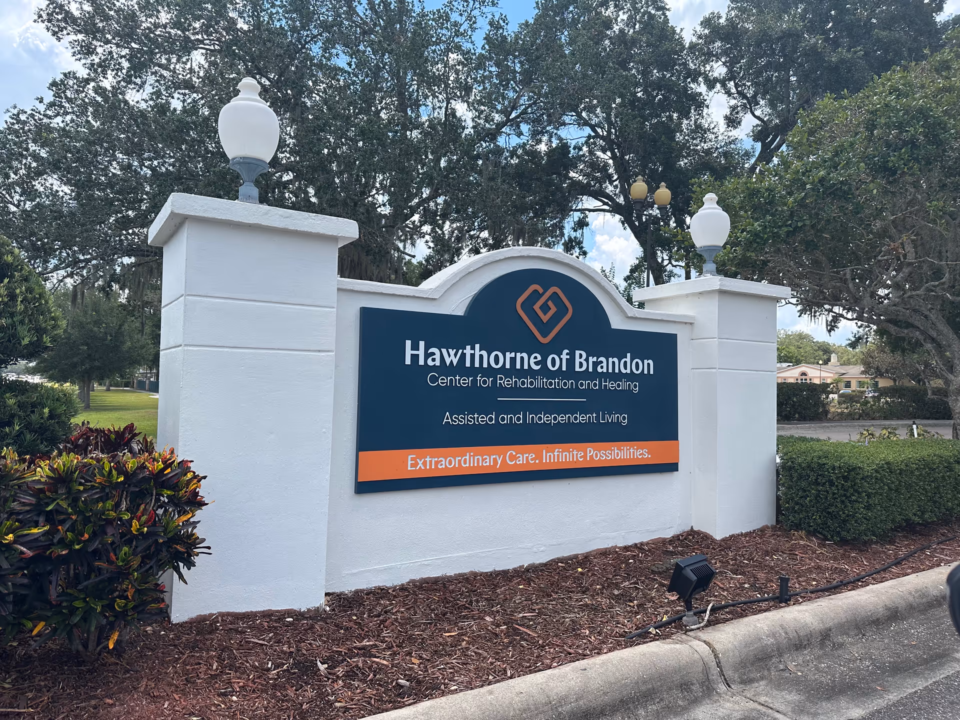 Entrance sign reading 'Hawthorne of Brandon, Center for Rehabilitation and Healing' with landscaping and lamp posts.