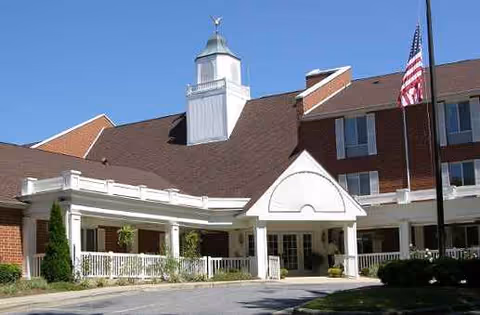 Exterior view of Kingston Residence of Hickory with a covered entrance and American flag.