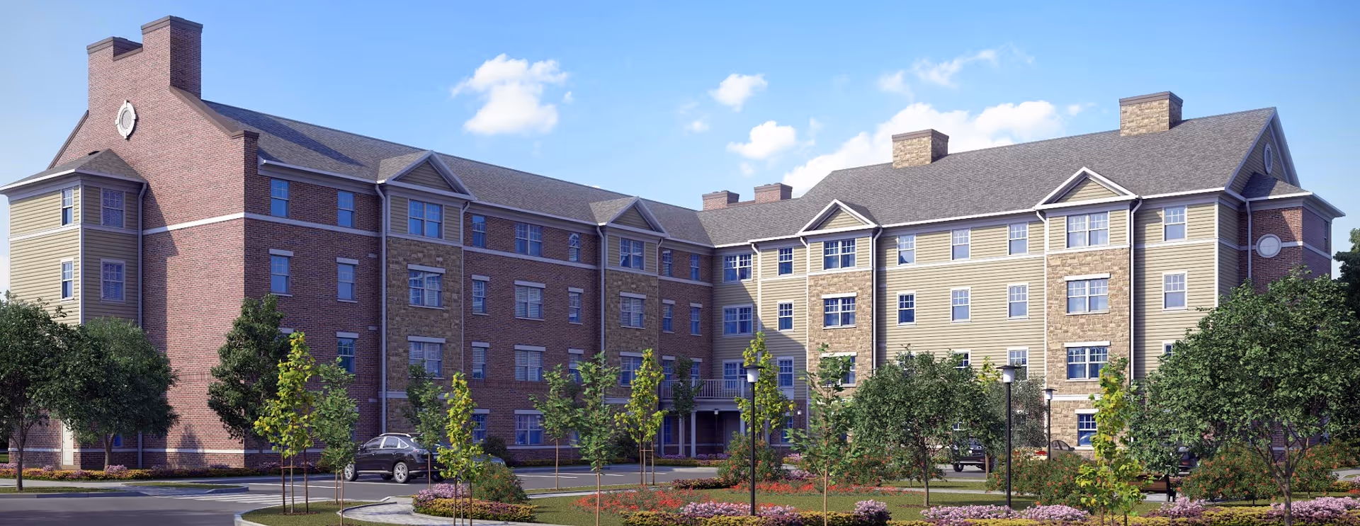Multi-story brick-and-siding senior living building with landscaped grounds under a blue sky.