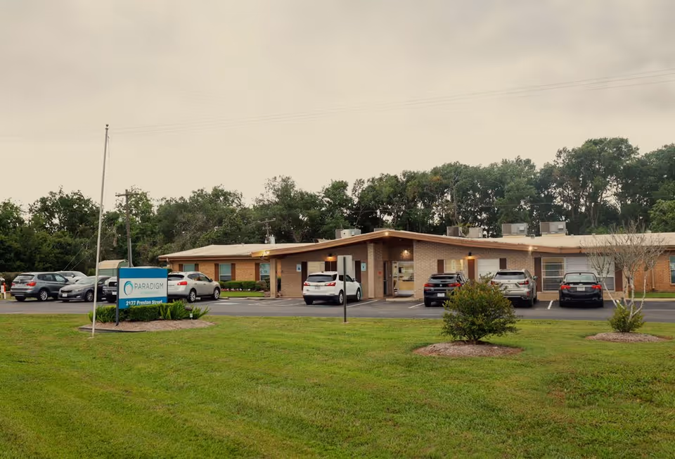 Exterior view of the Paradigm at the Brazos senior living facility with parking area.