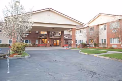 Exterior view of Gilman Grove facility entrance with driveway and landscaped grounds.