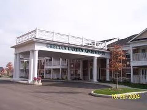 Exterior view of a senior living building with a covered entrance and columns.