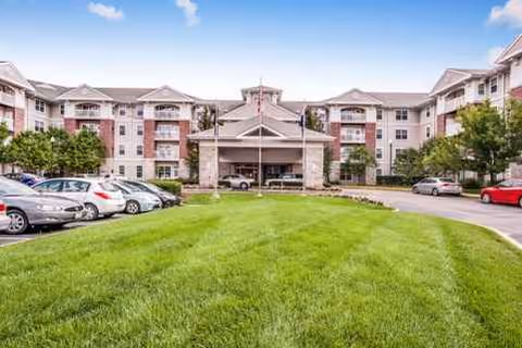 Fairwinds River's Edge exterior featuring a central entrance, surrounding lawn, and parked cars.