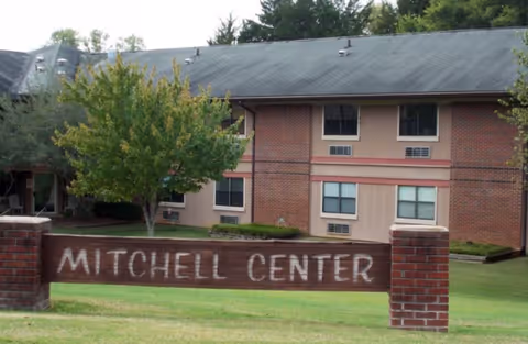Exterior view of a brick building with a Mitchell Center sign in front.