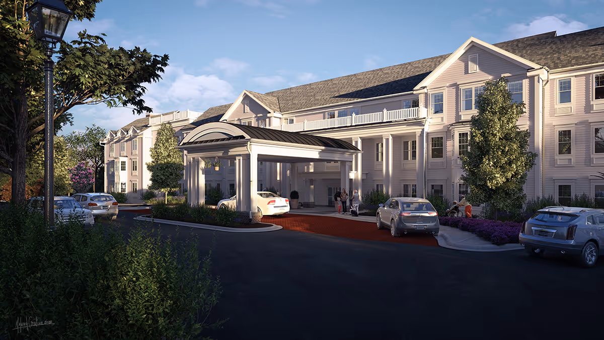 Exterior view of a large, multi-story senior living facility with a covered entrance driveway. Several cars are parked near the entrance, and a few people are standing or sitting nearby. The building is surrounded by trees, shrubs, and landscaped greenery under a partly cloudy sky.