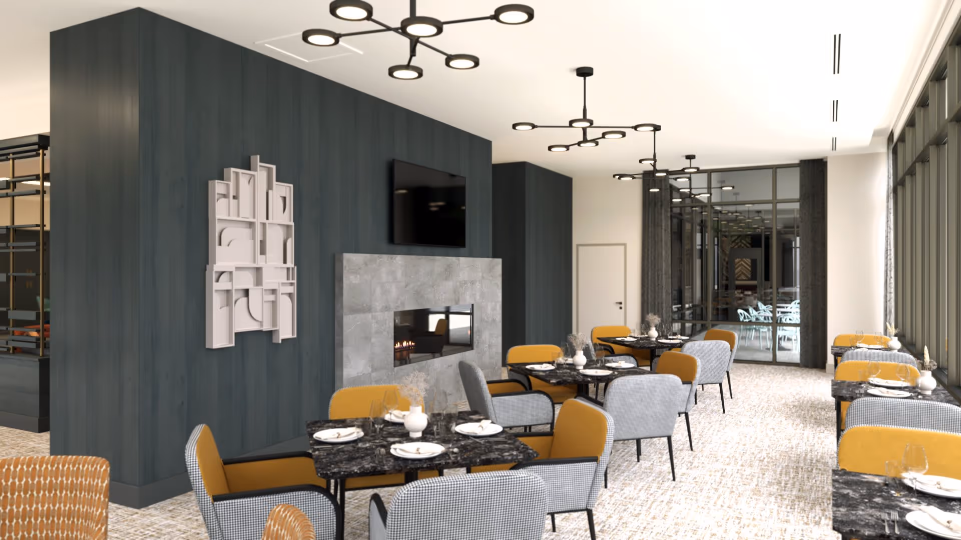 A modern dining room with multiple tables set with plates, glasses, and cutlery. The room features a dark wood accent wall with a mounted flat-screen TV above a sleek fireplace. The chairs are upholstered in a mix of mustard yellow and gray fabric. Large windows on the right side allow natural light to fill the space, and contemporary ceiling light fixtures hang overhead.
