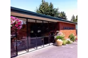 Front entrance of Alderwood Park Health & Rehabilitation with glass doors, brick exterior, potted plants, and the number '26' visible.