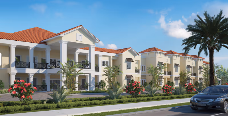 Exterior view of a two-story Mediterranean-style building with balconies, palm trees, and landscaped grounds.