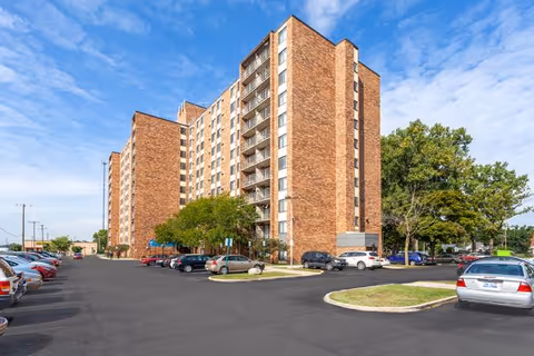 Exterior view of Ferndale Park Co-op, a brick senior living building with parked cars.