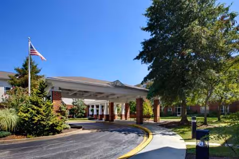 The front entrance of Heron Point of Chestertown with a porte-cochere and flag.