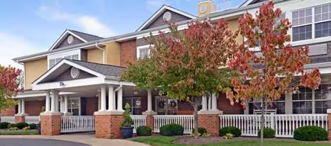 Exterior view of Stoney Ridge Senior Living with a covered entrance and fall trees.