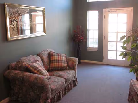 Cozy living room with floral sofa, plaid cushions, and a glass door.