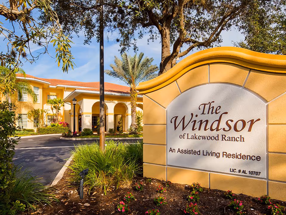 Entrance sign and landscaped front exterior of The Windsor of Lakewood Ranch assisted living residence.