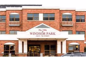 Brick, two-story senior living building with a prominent entrance and arched windows.