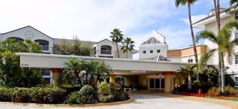 Exterior view of Brookdale North Boynton Beach showing the front entrance and palm landscaping.
