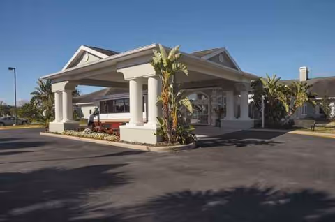 Front view of Life Care Center entrance with a covered drive and a bus.