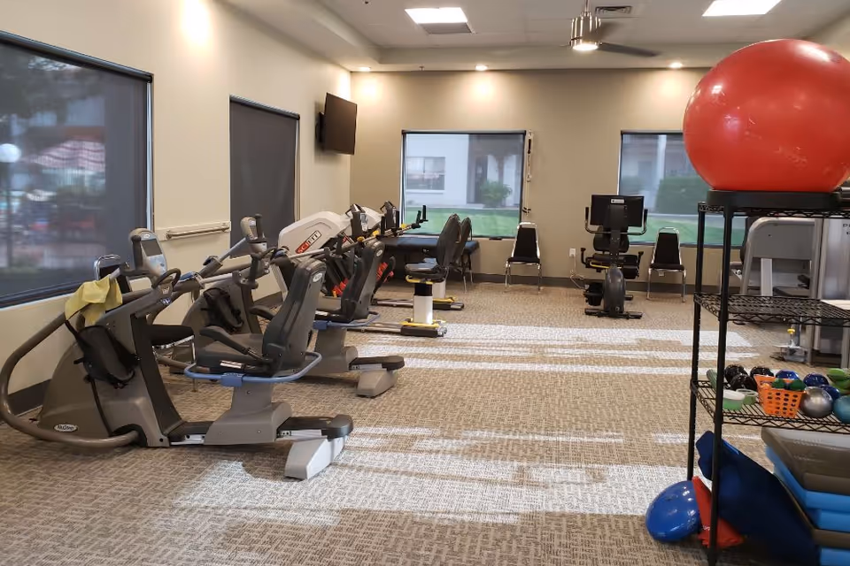 Interior fitness room with recumbent exercise bikes, exercise equipment and therapy balls.