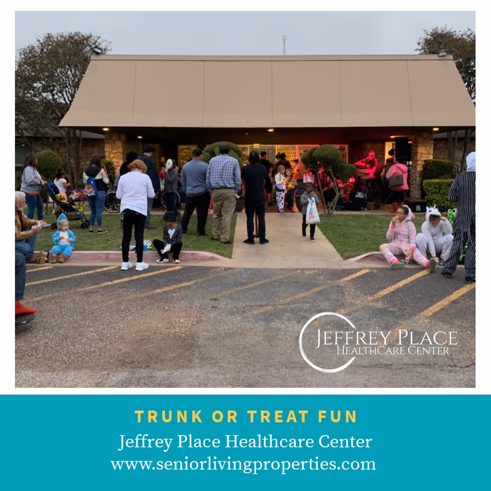 A crowd of people and children in costumes gathered outside the front entrance of Jeffrey Place Healthcare Center for a trunk-or-treat event.