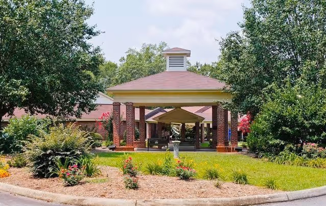 Exterior view of The Renaissance Senior Living entrance with brick columns and landscaped grounds.