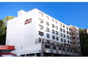 Exterior view of a multi-story building under a clear blue sky, with the name 'Park Gardens Rehabilitation & Nursing Center' visible on the side of the building.