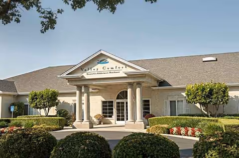 Exterior view of Valley Comfort senior living facility with entrance and landscaping.