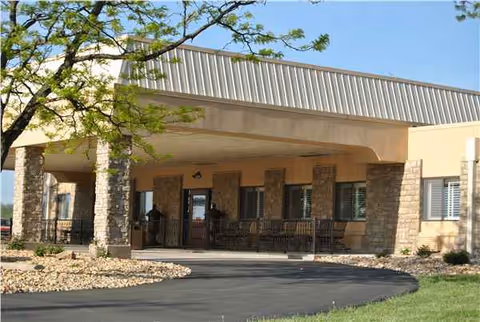 Exterior view of Warrenton Manor entrance with stone columns and covered porch.