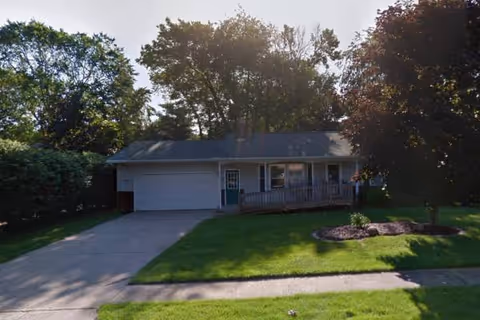 Front view of a single-story facility with an attached two-car garage and manicured lawn.