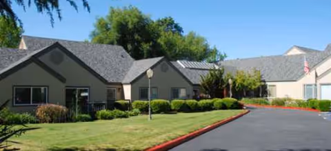 Exterior view of Blossom Vale Senior Living with green lawn and driveway.