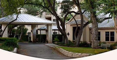 Exterior view of The Inn at Los Patios with a covered entrance and trees.