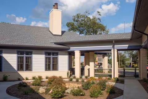 Exterior view of White Oak Manor Shelby facility entrance with garden beds