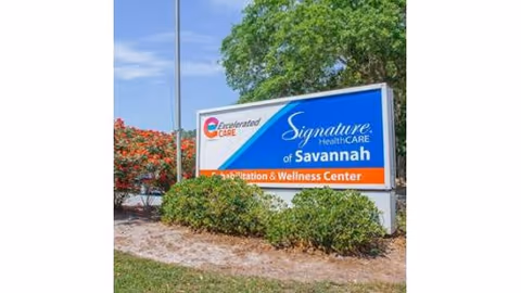 Outdoor landscaped sign reading 'Signature HealthCARE of Savannah' marking a rehabilitation and wellness center.