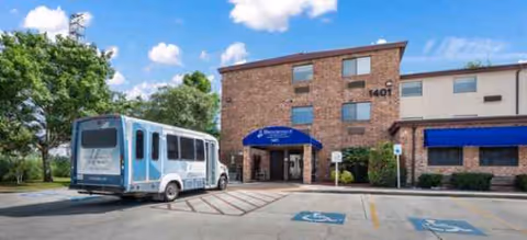 Front view of Brookdale San Marcos South with blue awning and shuttle bus