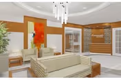 Interior lobby with beige seating, bright orange artwork, and a reception desk.
