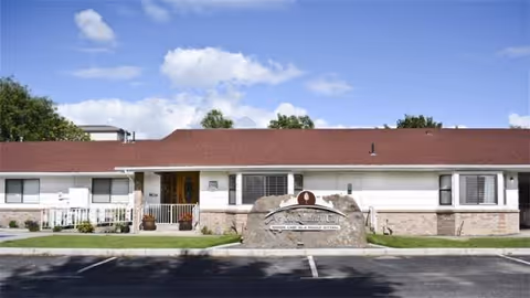 Front view of Aspen Quality Care Inc., a single-story senior living facility with a central sign.