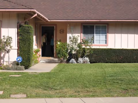 Front view of a pink, single-story facility with open entrance.