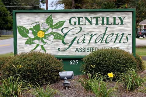 Outdoor sign for The Gardens Senior Living & Memory Care Community with landscaping.