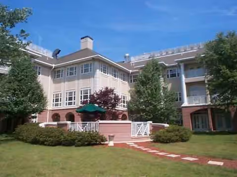 Exterior view of Ivy Hall Assisted Living building with lawn and steps