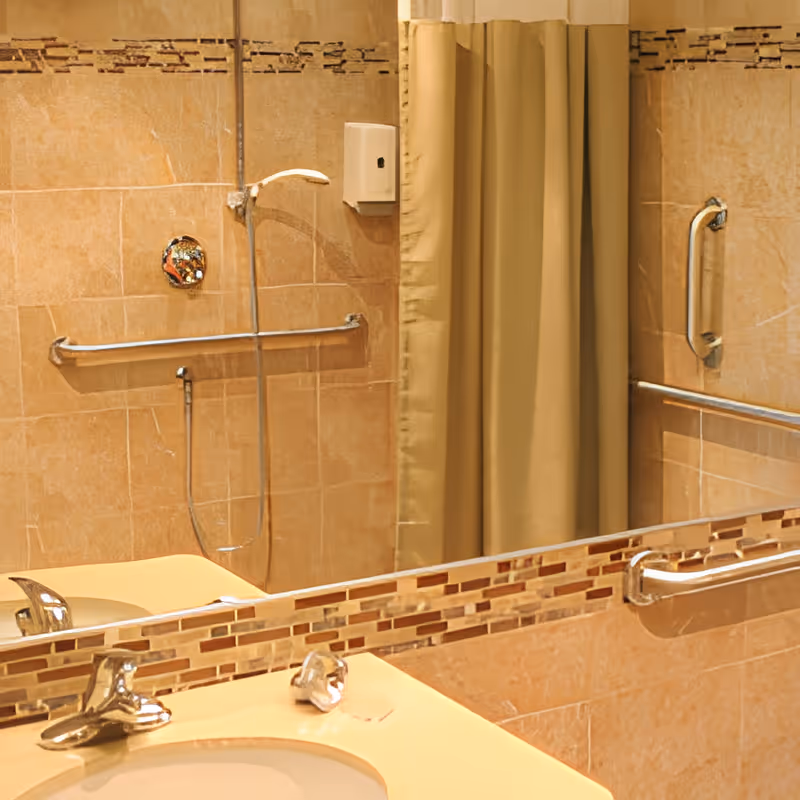 Bathroom with beige tiled walls, a shower area with grab bars, a shower curtain, and a sink with a faucet and a mirror above it.