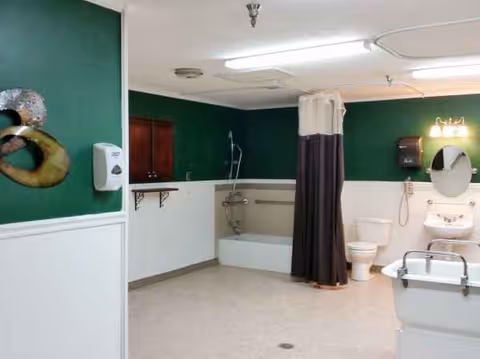 Accessible bathroom in a senior living center with shower, tub, toilet, and sink.