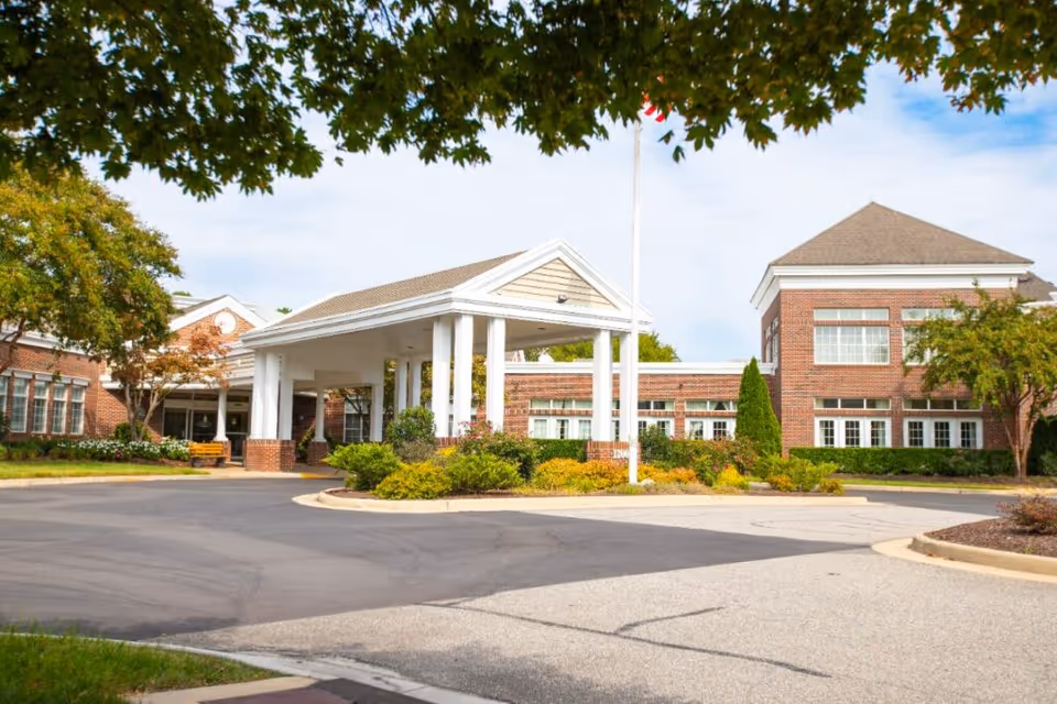 Exterior view of a senior living facility with a covered entrance and landscaped grounds