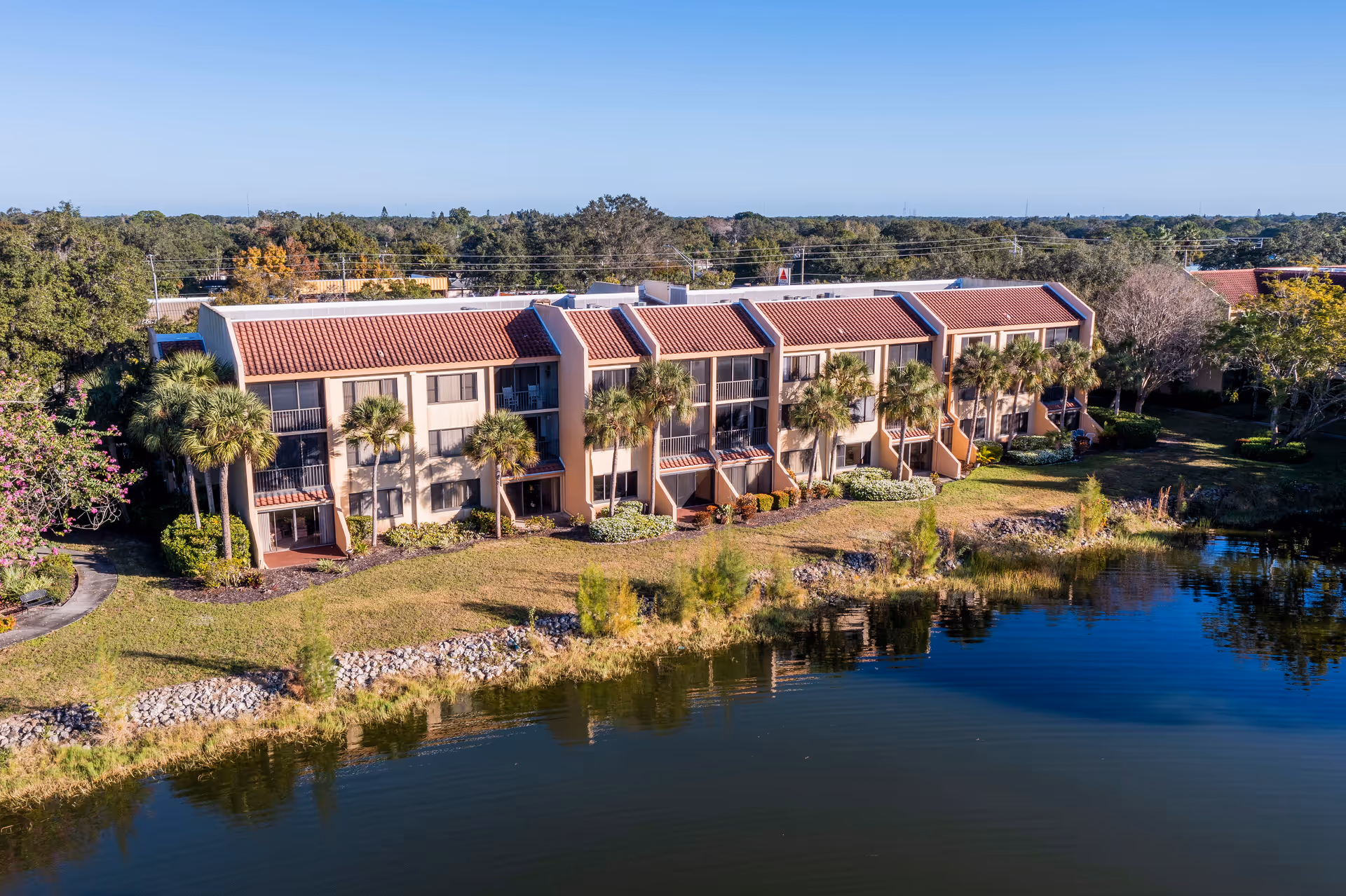 Aerial view of the American House Sarasota senior living facility by a water feature.