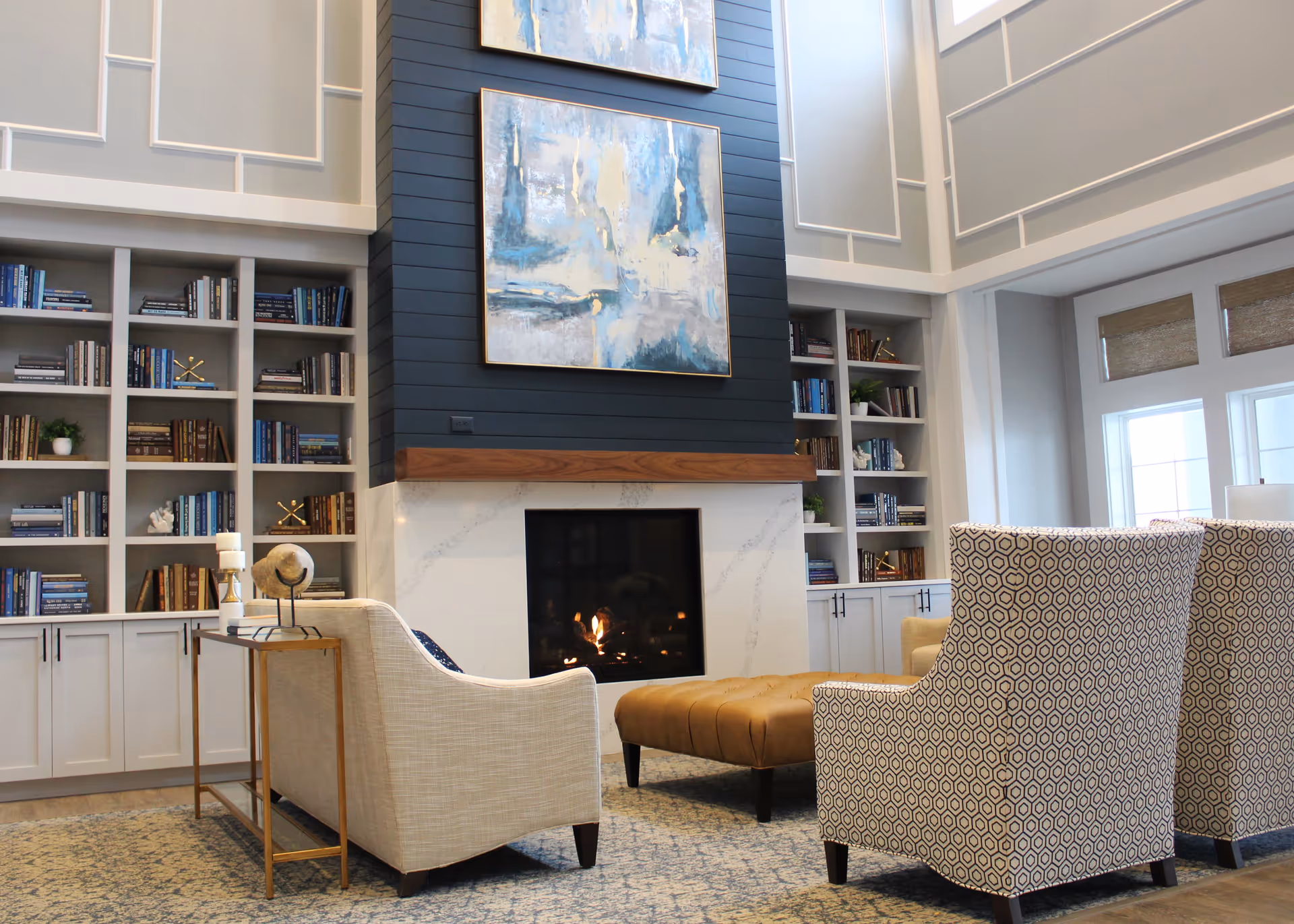 Spacious lounge with a central fireplace, built-in bookshelves, and upholstered seating.