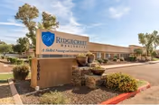 Front view of Ridgecrest Post Acute facility with sign, landscaping, and parking area.